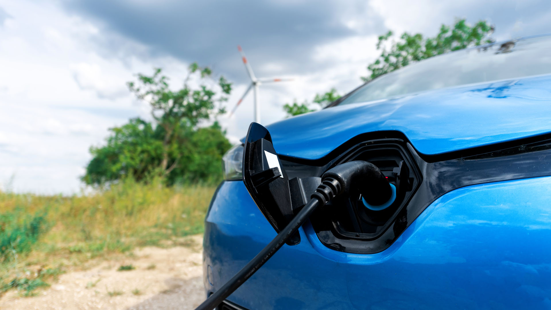 Close view of a charger plugged into an electric car Header Background